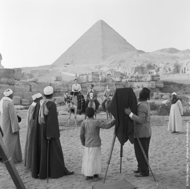 1950: A photographer taking a photograph of visitors to Giza (El Gizeh) in front of the Great Pyramid of Cheops (Khufu)