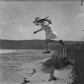 girl jumping onto beach