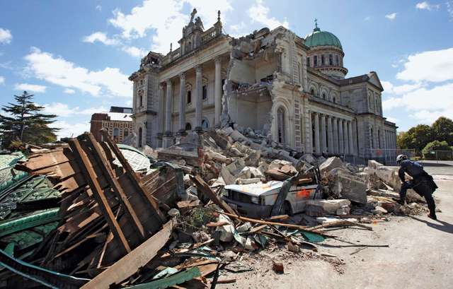 A worker surveying a pile of rubble two days after a massive earthquake, near the damaged Cathedral of the Blessed Sacrament, Christchurch, New Zealand, February 2011.